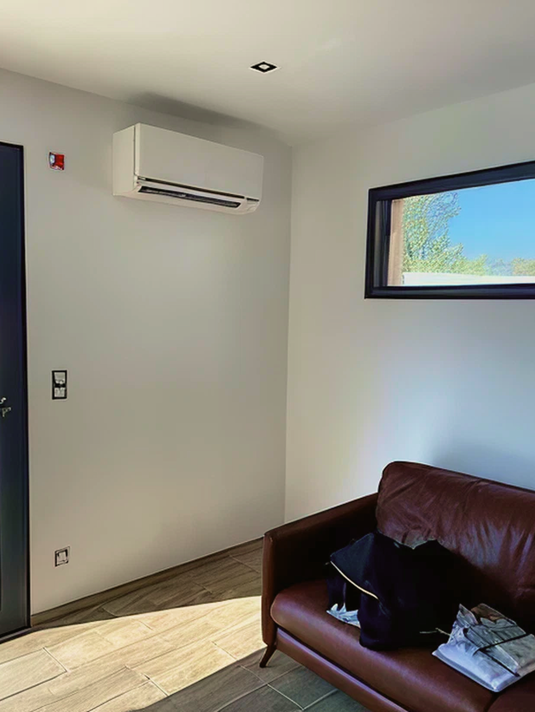 Climatiseur mural installé dans une chambre, près d’une fenêtre